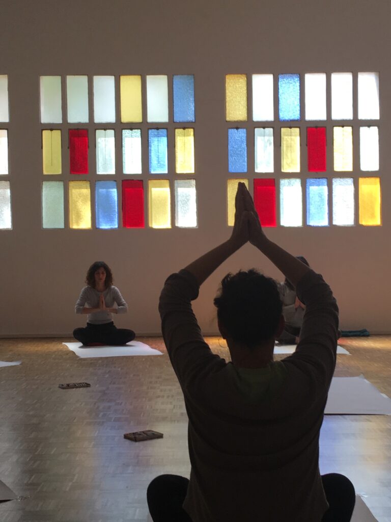 Práctica de meditación grupal en una sala con chimenea